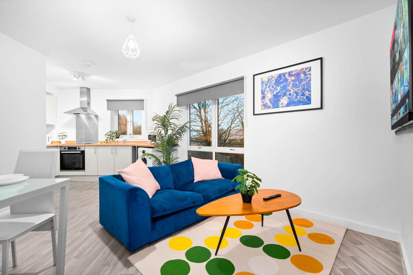 Un salon moderne avec un canapé bleu, une table basse et un tapis coloré.