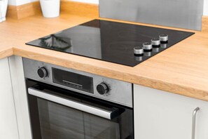 A kitchen with a built-in stove and oven, wooden countertop, and stainless steel cabinets. - Luxury Two Bedroom Apartment - Parking - Smart TV (Birmingham)