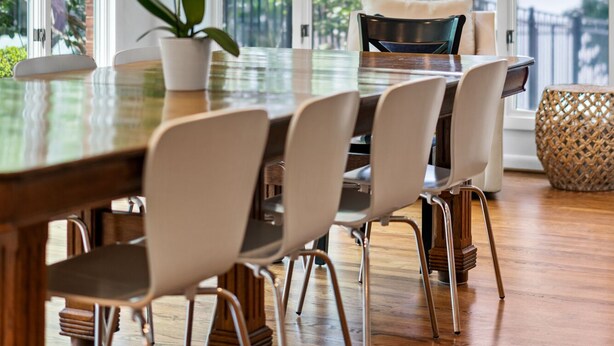 Un comedor moderno con una mesa grande, sillas y un ventilador de techo.