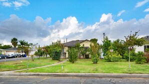 Zona residencial con una casa, césped y calle.