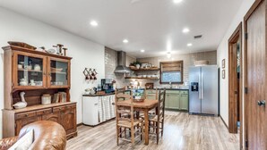 Una cucina moderna con mobili in legno, un tavolo da pranzo e un frigorifero.