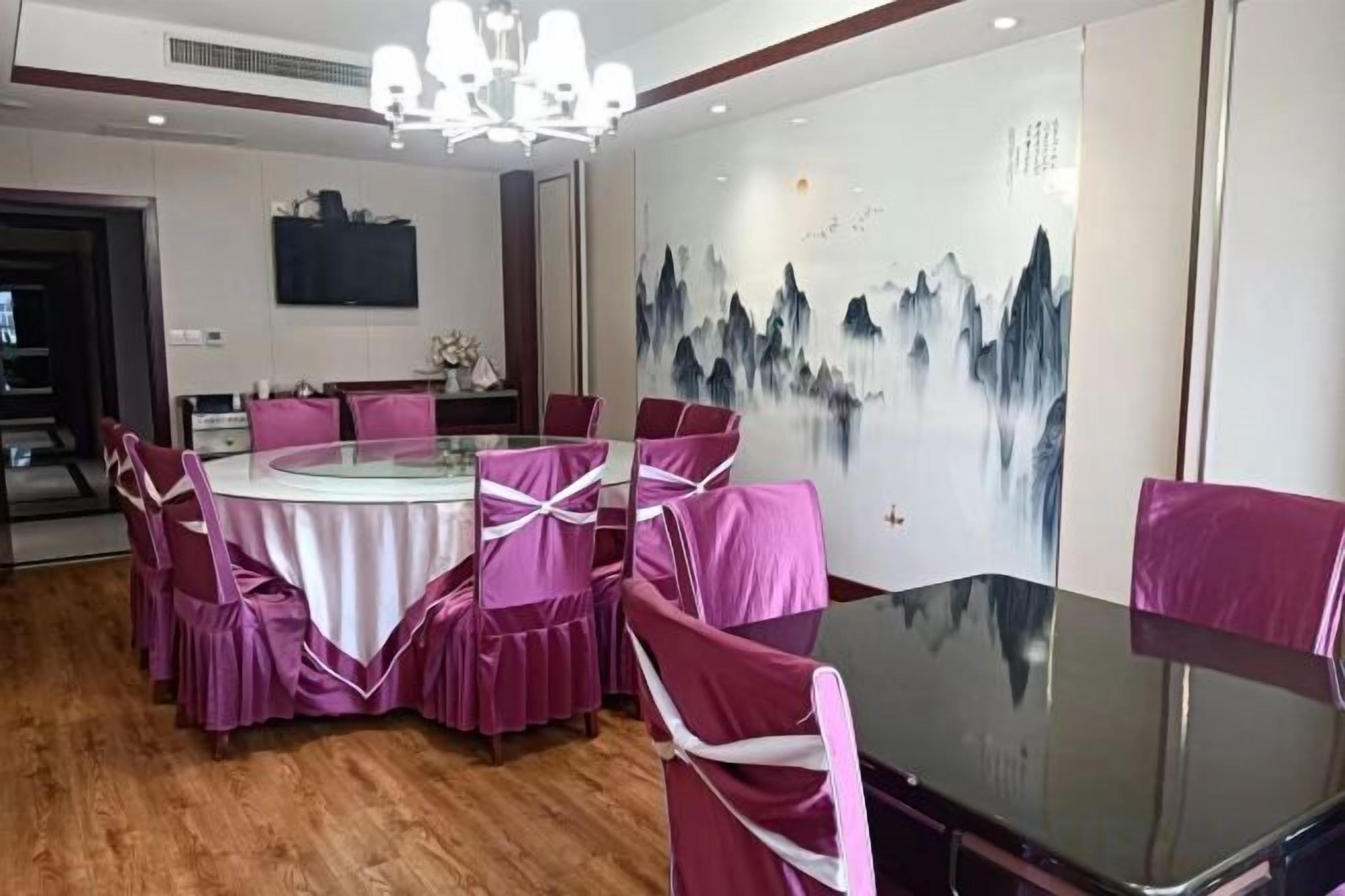 A dining area with a round table, chairs, and a wall mural.