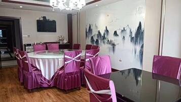 A dining area with a round table, chairs, and a wall mural.