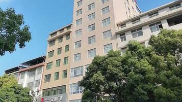 A multi-story building with a commercial ground floor, large windows, and a visible sign.