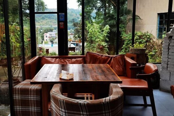 A cozy seating area with a wooden table and plaid-patterned cushions.
