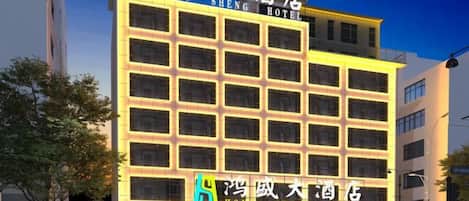 A multi-story hotel with illuminated signage, a prominent entrance, and a structured facade.
