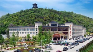 Un hotel con una pagoda tradicional en una colina, rodeado de exuberante vegetación.