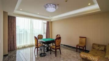 A room with a pool table, four chairs, a sofa, and a chandelier.