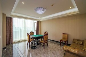 Una habitación con mesa de billar, cuatro sillas, sofá y candelabro.