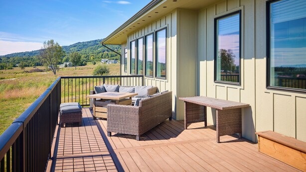 Una terraza con muebles de mimbre, una mesa y un banco.