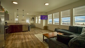 Un amplio salón con cocina, comedor y un gran ventanal con vistas a la montaña.