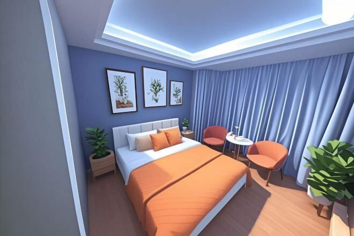 Un dormitorio moderno con una cama, dos sillas, una mesita y una mesita de noche.