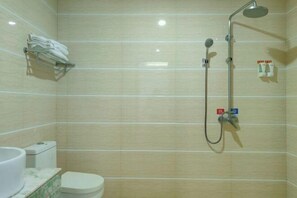 A bathroom with a toilet, a sink, and a shower with a handheld showerhead.