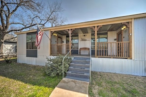 A single-story building with a porch, a flag, and a staircase leading to the entrance. - 'The Barn' Fredericksburg Wine Country Retreat (Fredericksburg)