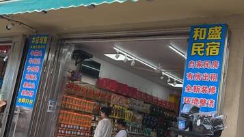Fachada de una tienda con un letrero azul que anuncia un apartamento amoblado para alquiler.