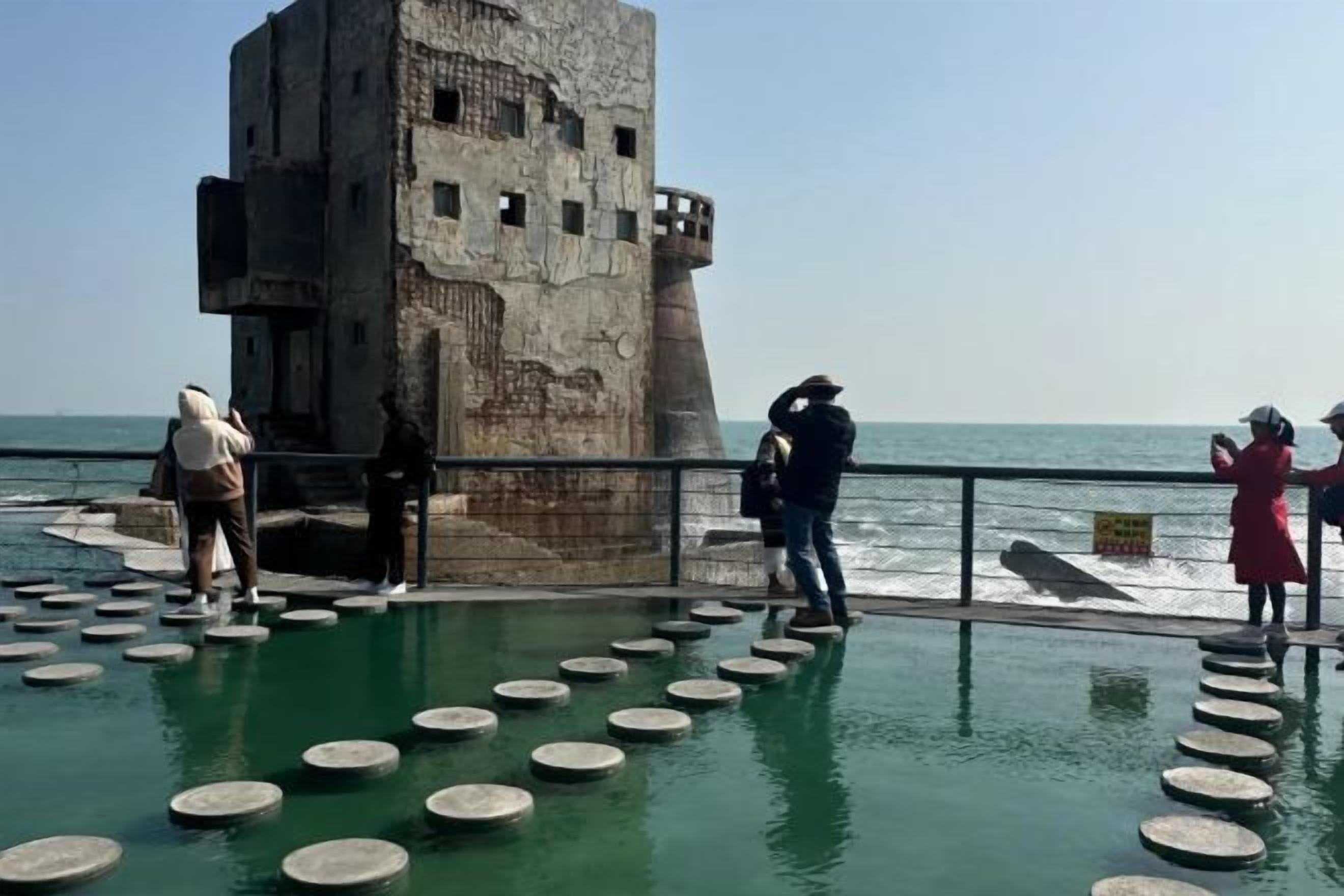 Una fortificación costera con una disposición circular de escaleras que conducen hasta ella, con vistas al mar.