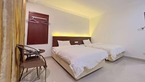 A hotel room with two beds, a chair, a wooden door, and a wall-mounted coat rack. - Red Bay Hesheng Homestay (Shanwei)