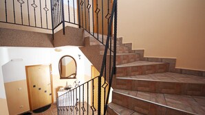 Una escalera con barandilla y una puerta al final.