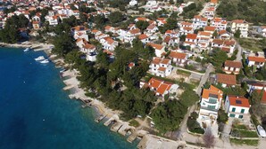 An aerial view of a coastal residential area with houses, a marina, and clear blue waters. - Apartments & Rooms Villa Petra - One Bedroom Apartment with Balcony and Sea View - 2 (Žaborić)
