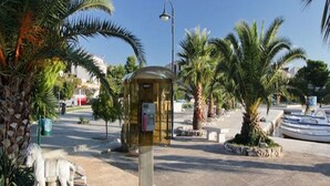 A public square with palm trees, a small kiosk, and a statue of horses. - Apartments & Rooms Villa Petra - One Bedroom Apartment with Balcony and Sea View - 2 (Žaborić)