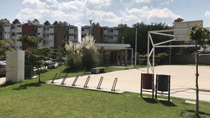 Ein Innenhof mit Fahrradständer, Sitzgelegenheiten und einem mehrstöckigen Gebäude im Hintergrund.
