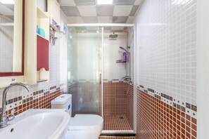 Ein Badezimmer mit Dusche, Waschbecken und Toilette.