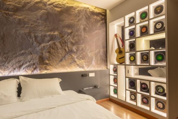 A bedroom with a bed, a guitar, and a wall-mounted display of various items. - Dali Old Time Seaview Inn (Dali City)