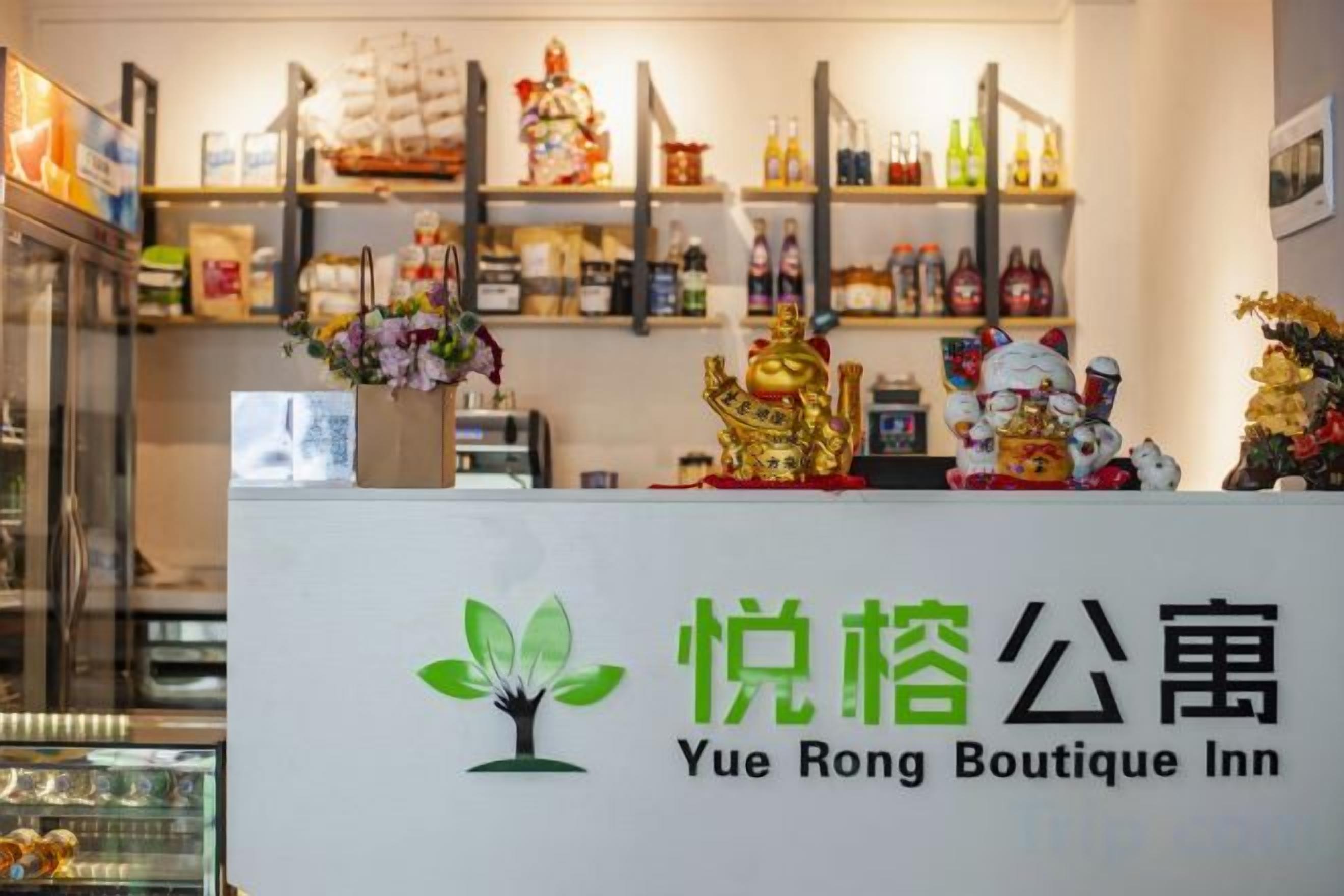 A reception desk with a sign for Yue Rong Boutique Inn, featuring a logo with a tree and the inn's name.