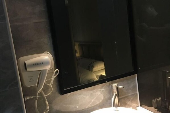 A hotel room with a hairdryer, a mirror, and a sink. - Yuerong Boutique Hotel (Zhuhai)