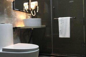 A modern bathroom with a toilet, a sink, and a shower area. - Yuerong Boutique Hotel (Zhuhai)