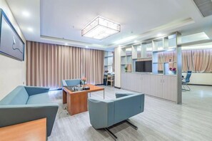 A modern hotel room with a living area, a dining table, and a kitchenette. - Yike Hotel (Guangzhou Baiyun International Airport) (Guangzhou)