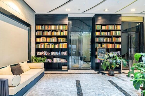 Una biblioteca moderna con estanterías, un sofá y plantas en macetas.