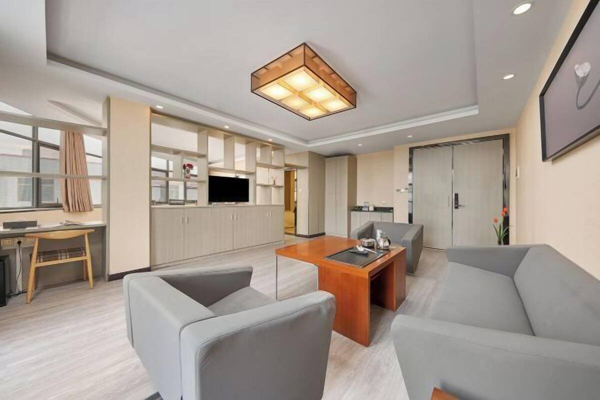 A modern living room with a sofa, a coffee table, and a TV.