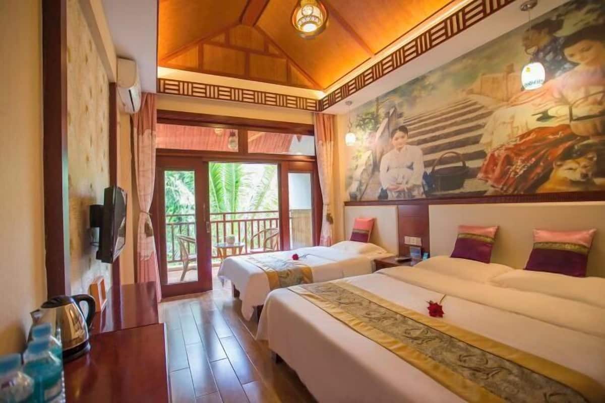 Une chambre d’hôtel avec deux lits, un plafond en bois, une fresque murale et un balcon.