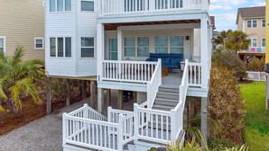 Ein zweistöckiges Haus mit Balkon und überdachter Veranda.