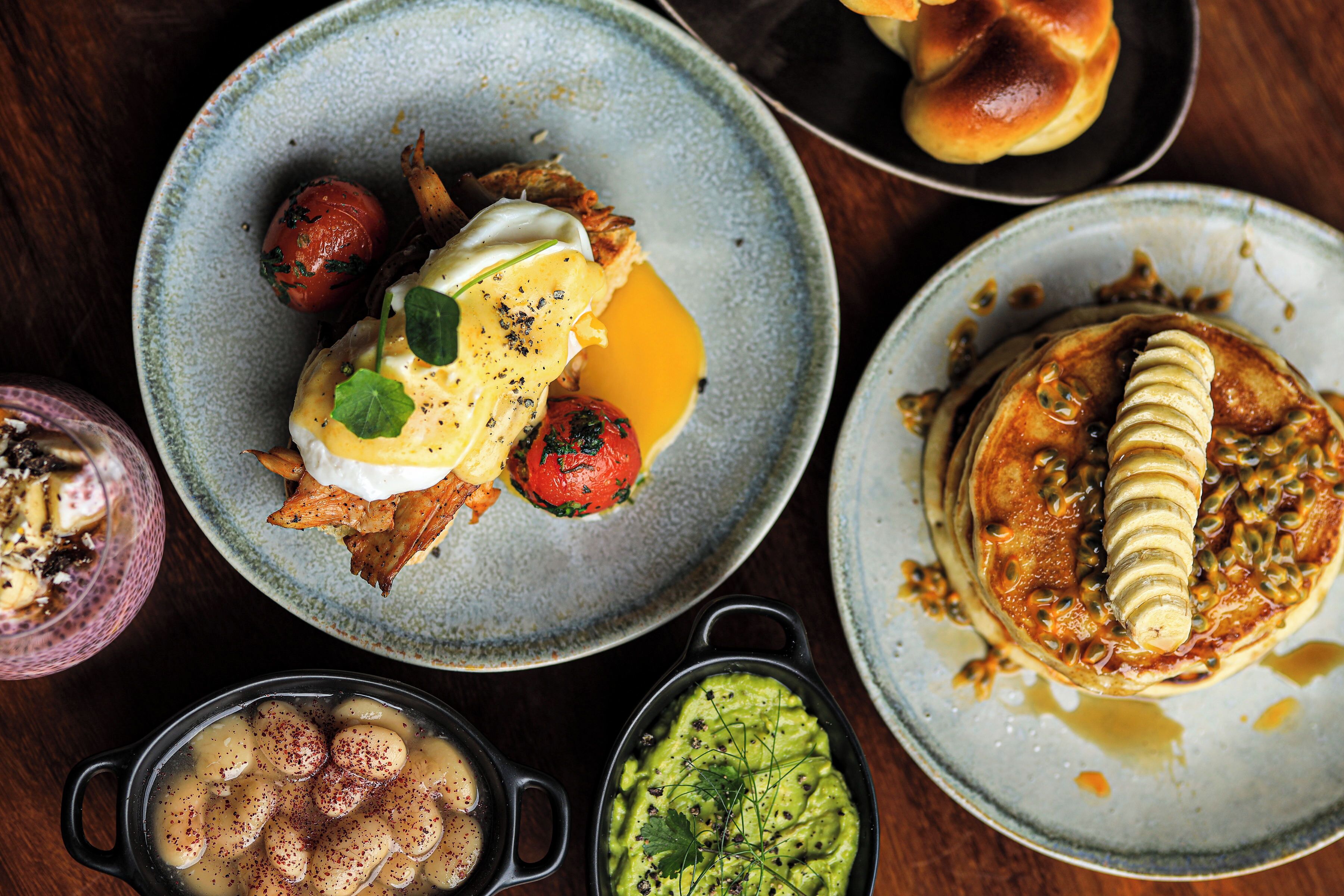 A variety of breakfast dishes including eggs, pancakes, and a bowl of soup.
