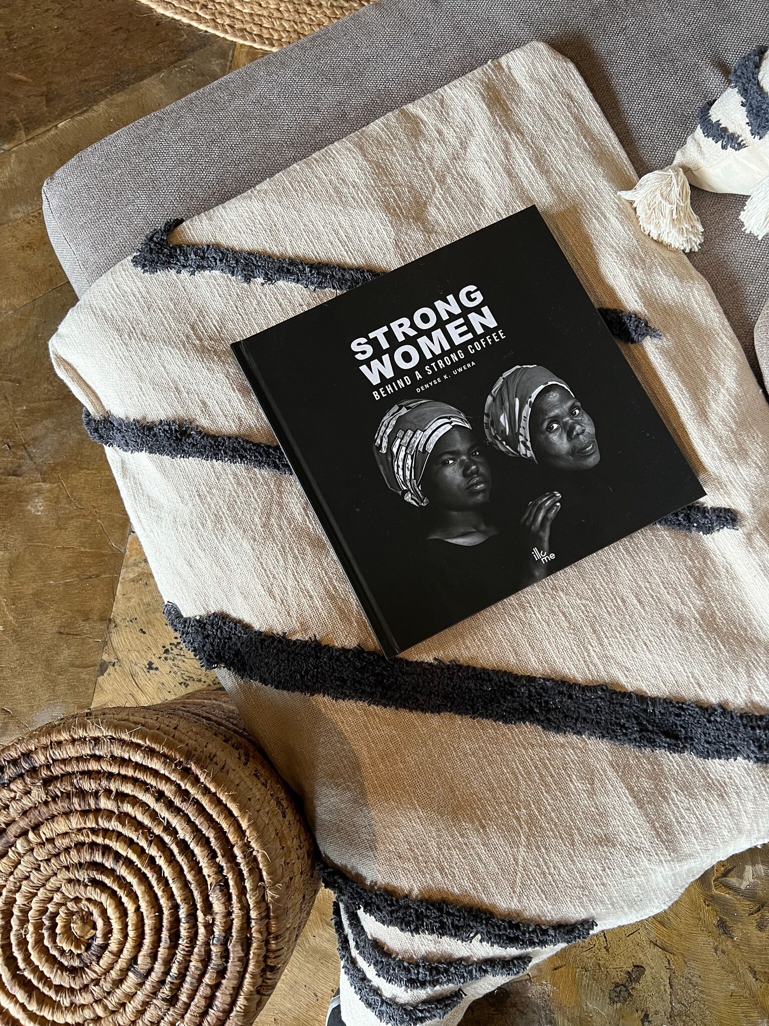 A book titled "Strong Women" on a textured fabric surface.