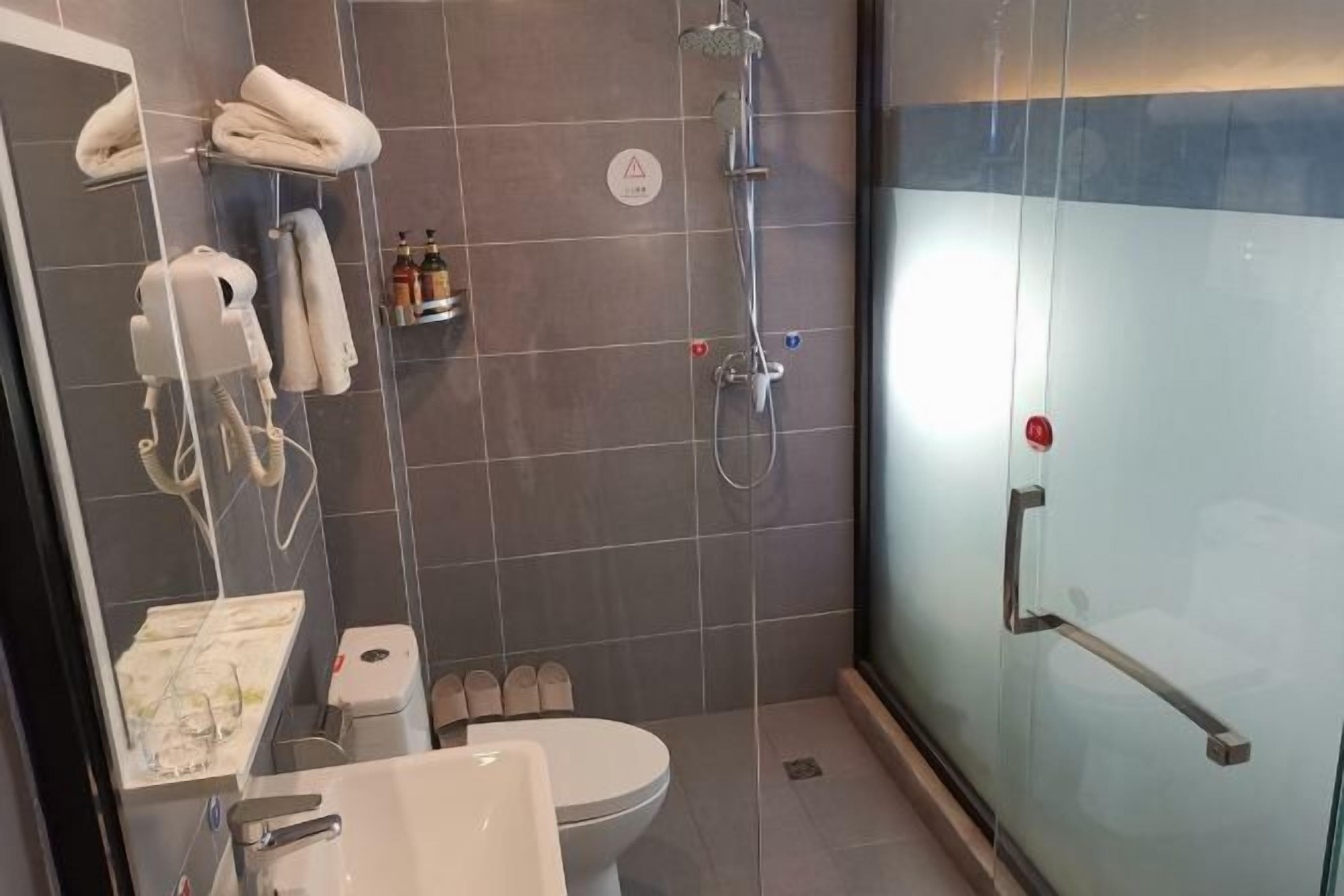 Une salle de bain moderne avec une douche à parois de verre, des toilettes et un lavabo avec un miroir.
