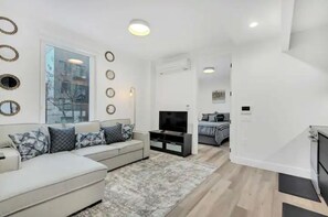 Relax in this stylish living room with a sofa, flat-screen TV, and large window offering a view.