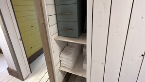 Ein Zimmer mit einer grünen Tür, weißen Wänden und einem blauen Schrank mit Schubladen.