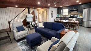 Ein gemütliches Wohnzimmer mit Kamin, Essbereich und einer Küche mit modernen Geräten.