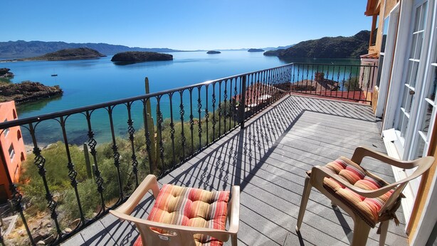 A balcony with a view of a calm lake and distant mountains. - Sunrise Villa - Off-Grid Beach Villa w/ Best Views in Baja California! (Heroica Mulegé)