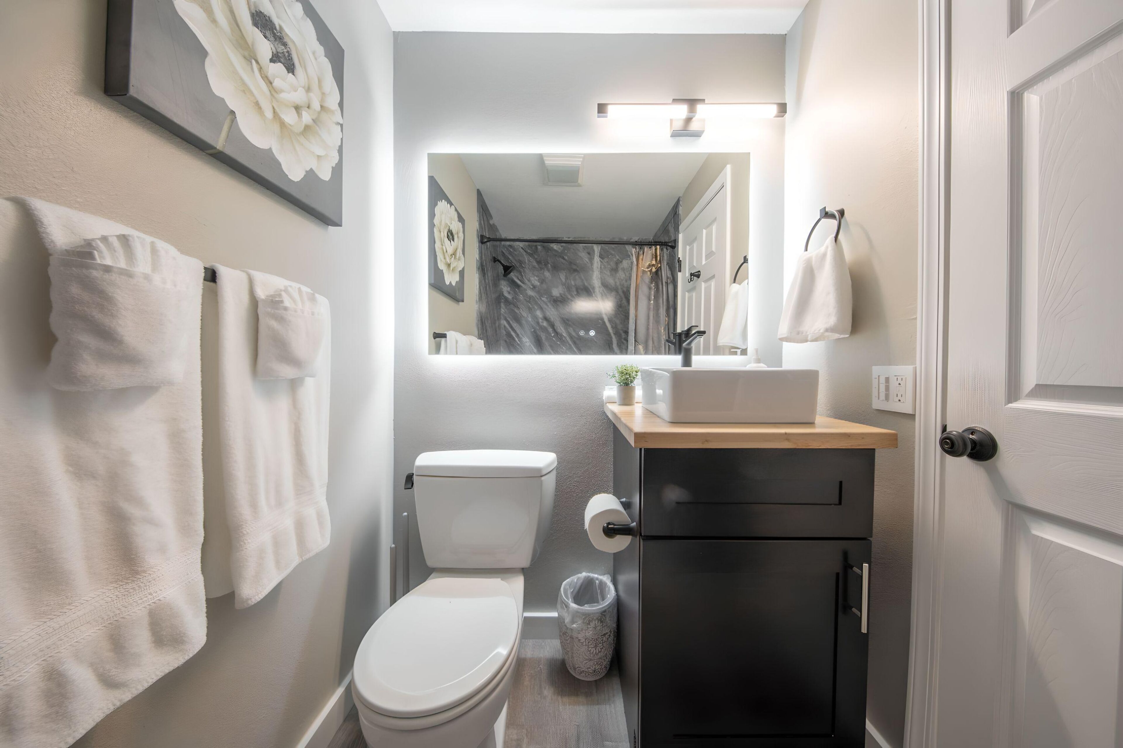 A modern bathroom with a toilet, sink, and cabinet.