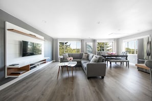 Apartament Deluxe | Sala d'estar | Televisor intel·ligent de 50 polzades amb canals per cable i televisor