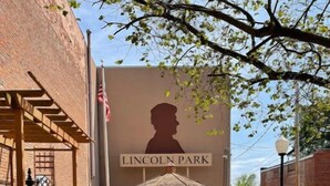 A brick pathway leading to a gazebo with a Lincoln Park sign in the background. - Unique apartment in historic downtown (Vandalia)