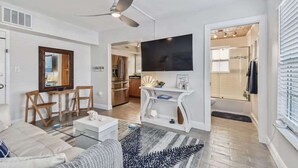 Uma sala de estar moderna com um sofá, mesa de centro e uma TV de tela plana na parede.