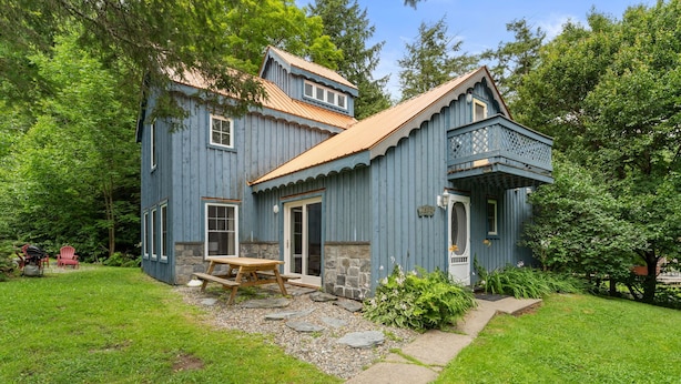 A two-story blue house with a stone foundation, a wooden deck, and a stone pathway leading to the front door. - Chalet 3 Min to Smuggs | Fire Pit | Dog-Friendly (Cambridge)