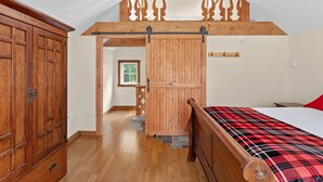 A bedroom with a wooden bed, a wardrobe, and a lofted sleeping area. - Chalet 3 Min to Smuggs | Fire Pit | Dog-Friendly (Cambridge)