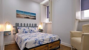 Une chambre à coucher avec un lit, des lampes de chevet, une chaise et une fenêtre donnant sur la plage.
