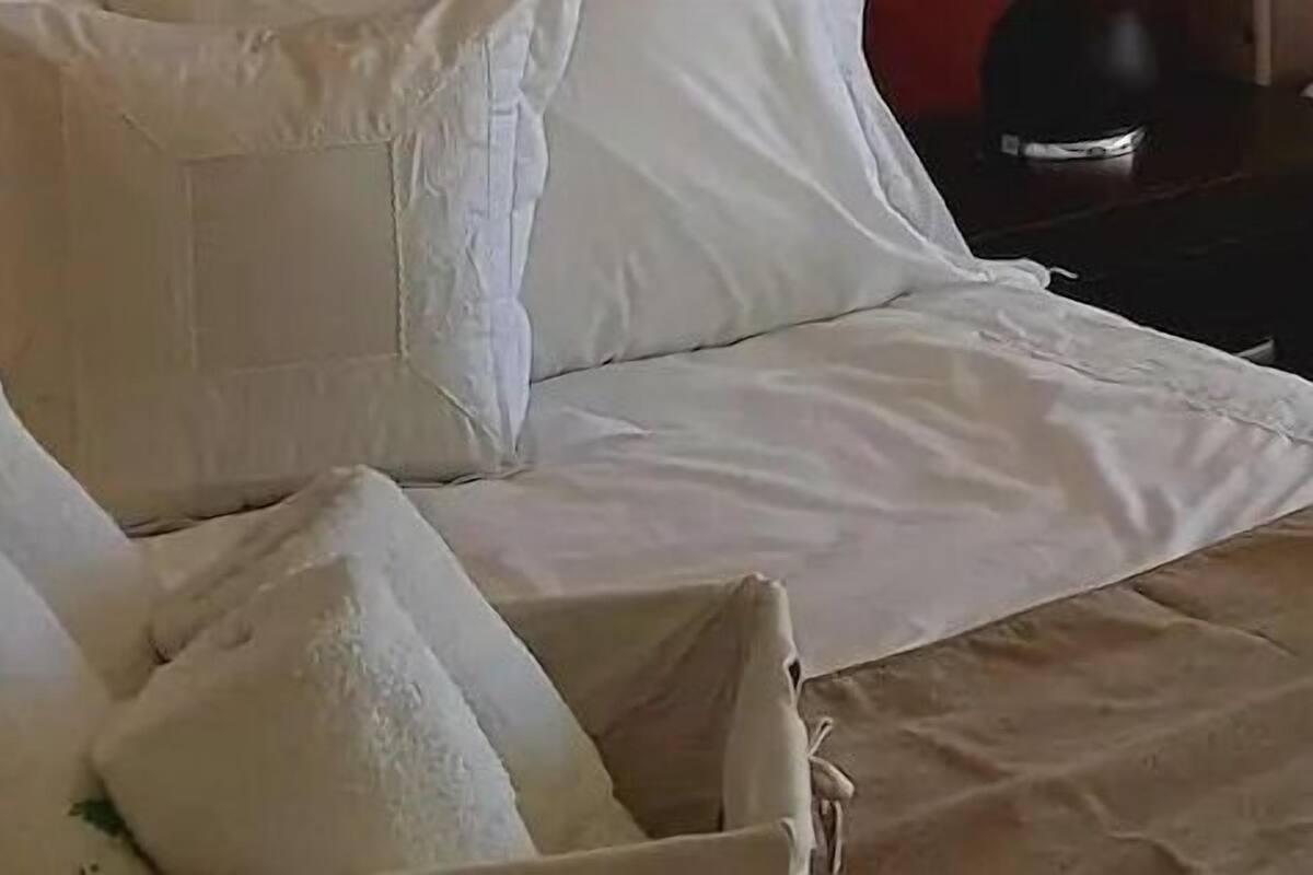Un lit avec une literie et des oreillers blancs.